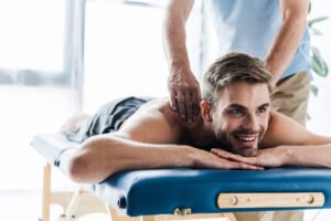 cropped-view-of-chiropractor-doing-massage-to-happ-LDGQK3J.jpg
